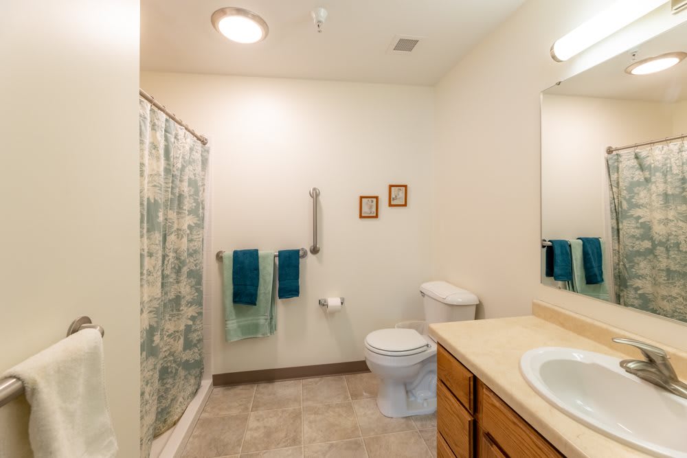 A clean and simple bathroom with a shower, toilet, and sink.