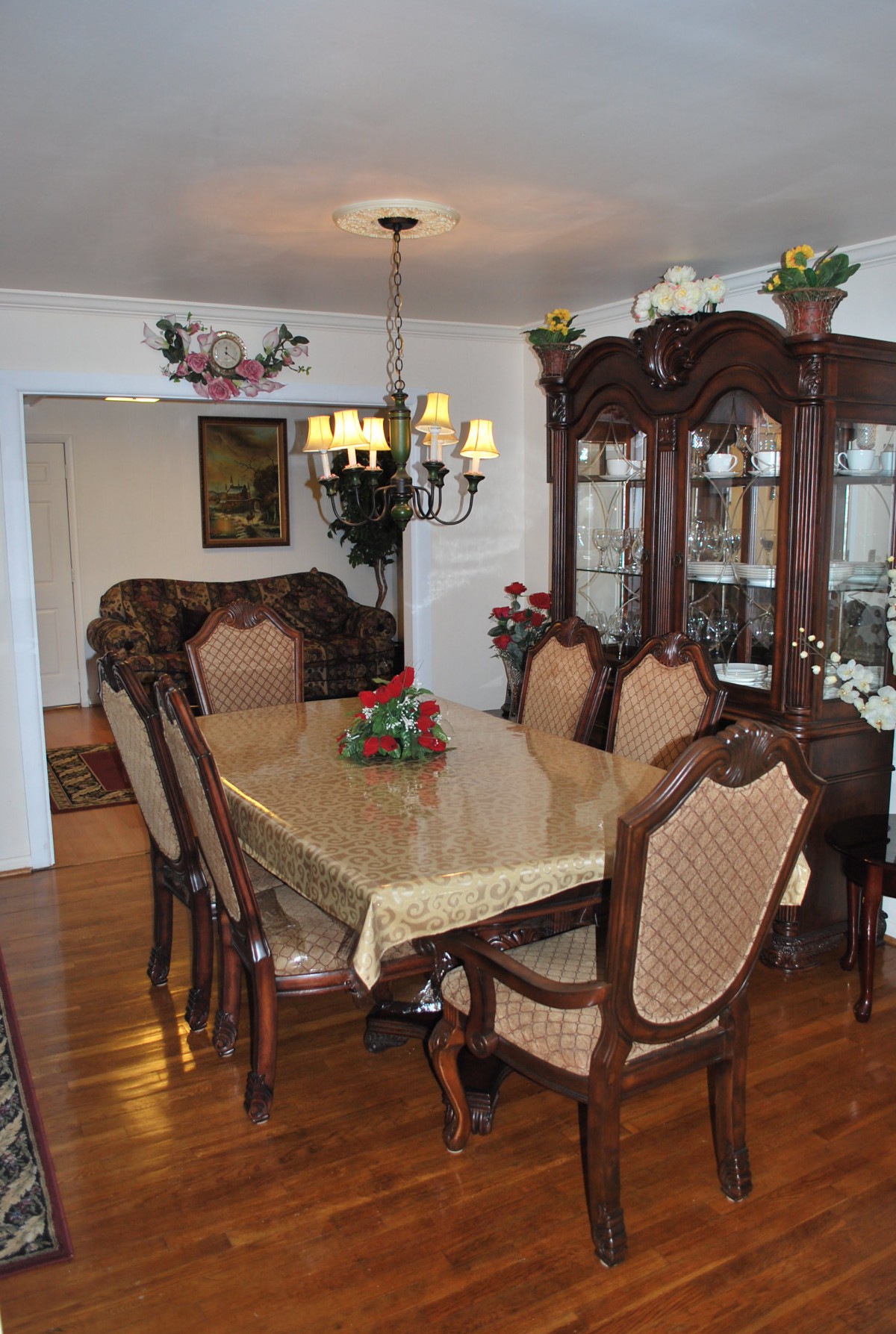 A traditional dining room with a wooden table, chairs, and a chandelier.