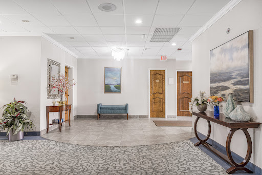 A welcoming lobby featuring a seating area, decorative artwork, and wooden doors.
