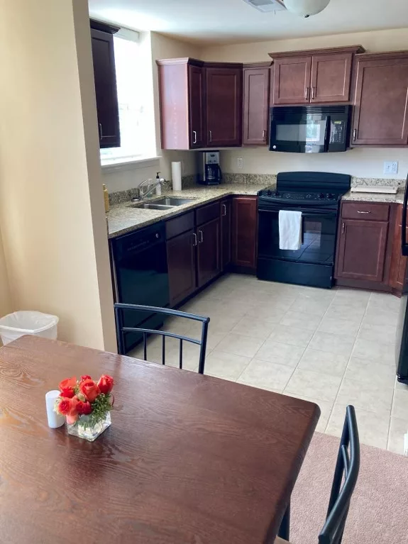 A modern kitchen with wood cabinets and a dining table adorned with flowers.