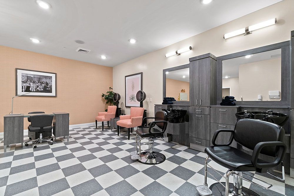 A modern salon interior with checkered flooring, styling chairs, and mirrors.