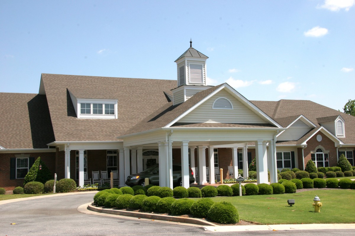 A picturesque clubhouse with a well-maintained entrance and lush landscaping.