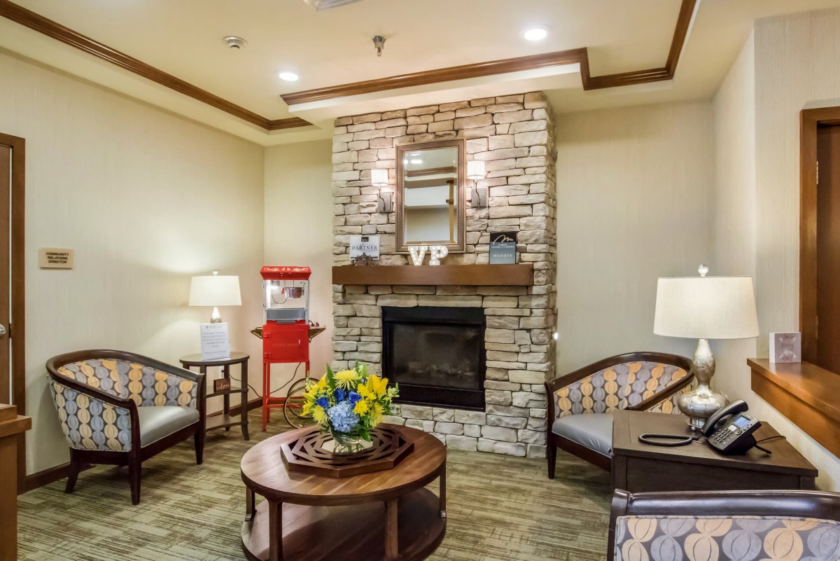 A cozy living room with a stone fireplace and comfortable seating.