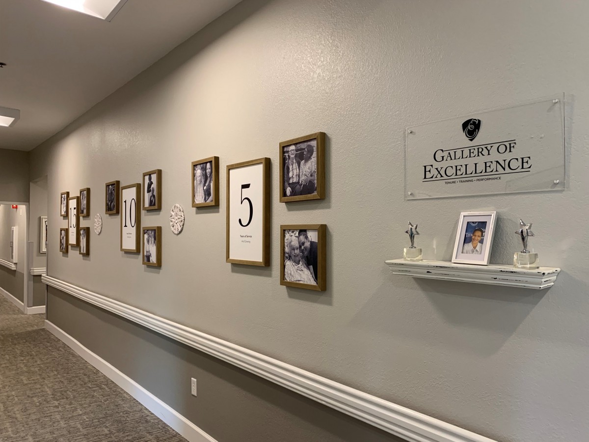 A hallway featuring a gallery of framed photographs and a 'Gallery of Excellence' sign.