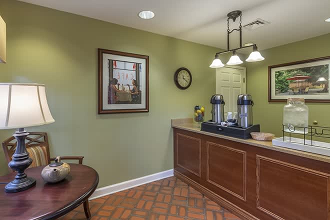 A cozy lobby area with a coffee station, artwork, and soft lighting.