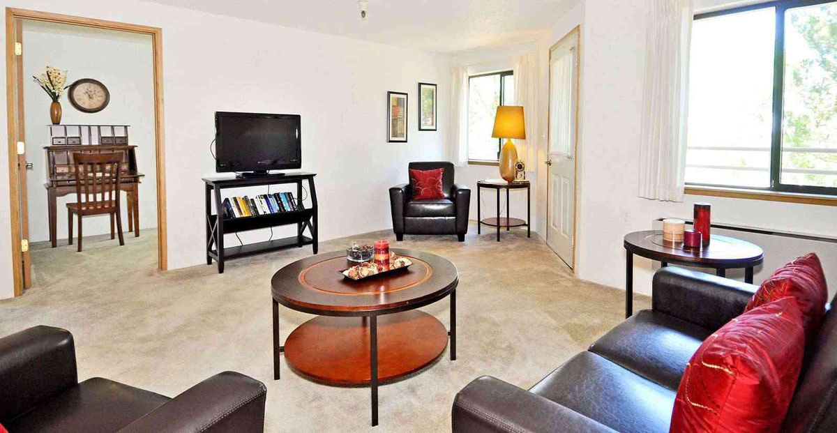 A cozy living room with modern furniture and a television.
