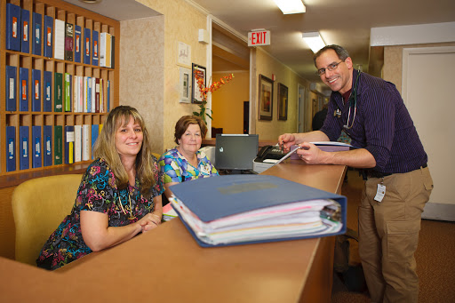 A friendly reception area with staff assisting at the front desk.