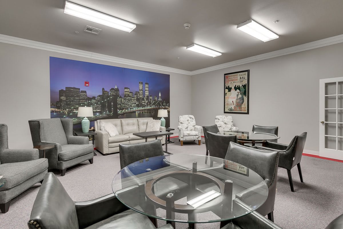 A modern office lounge with comfortable seating arrangements and cityscape decor.