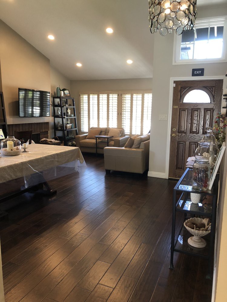 A cozy living room with a dining table, sofa, and hardwood floors.
