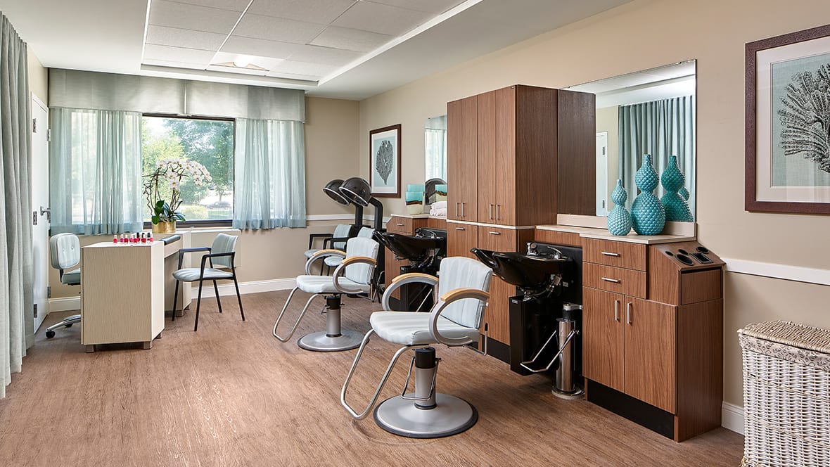 A modern hair salon interior with stylish chairs and wooden cabinets.