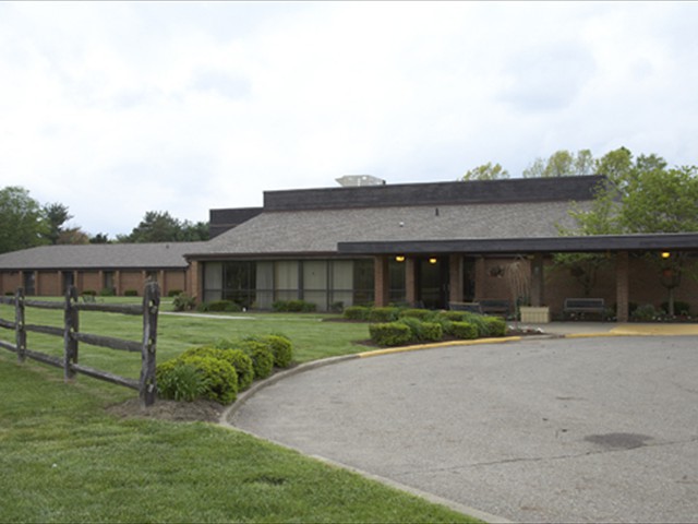 A school building with a driveway and well-maintained landscape.