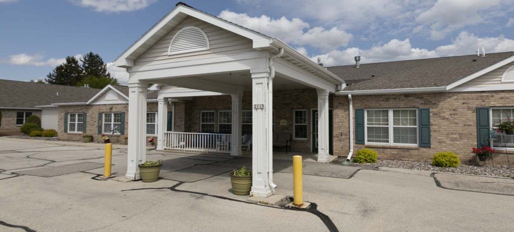 A residential building with a covered entrance and columns.