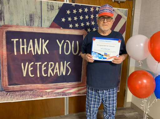A proud veteran holding a certificate of appreciation during a thank you event.