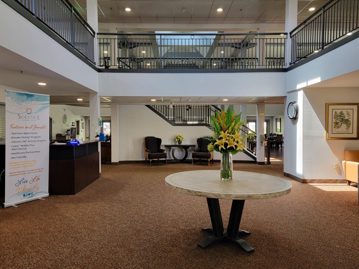 A spacious hotel lobby with a round table centerpiece and elegant interior design.