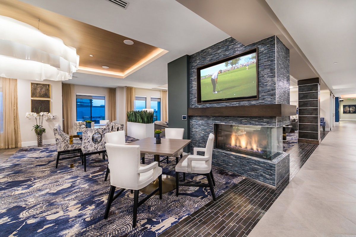A modern lounge with a fireplace and television, featuring comfortable seating and stylish decor.