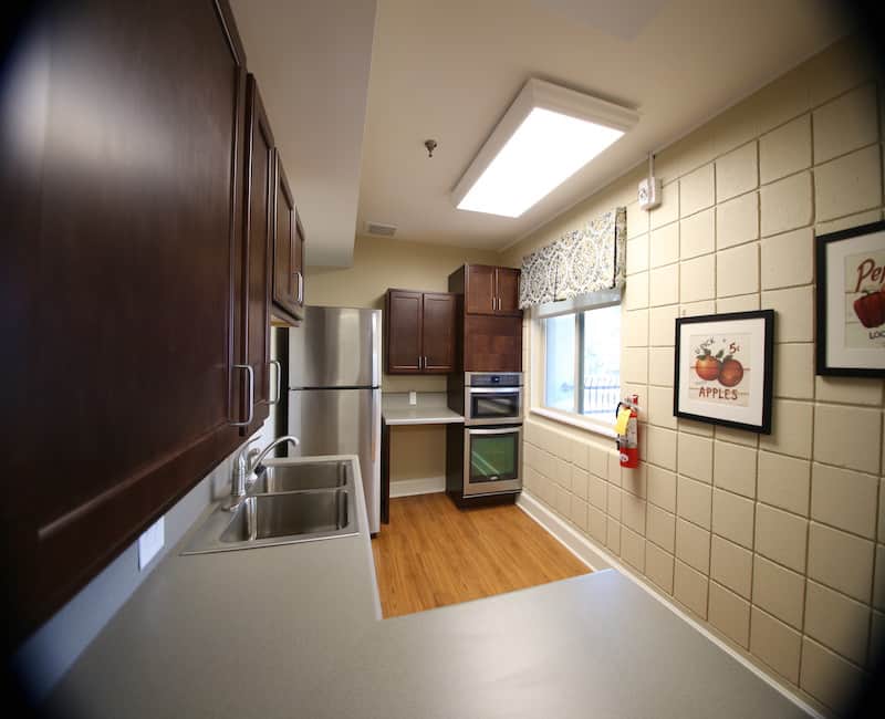 A modern kitchen with dark wood cabinets and stainless steel appliances.