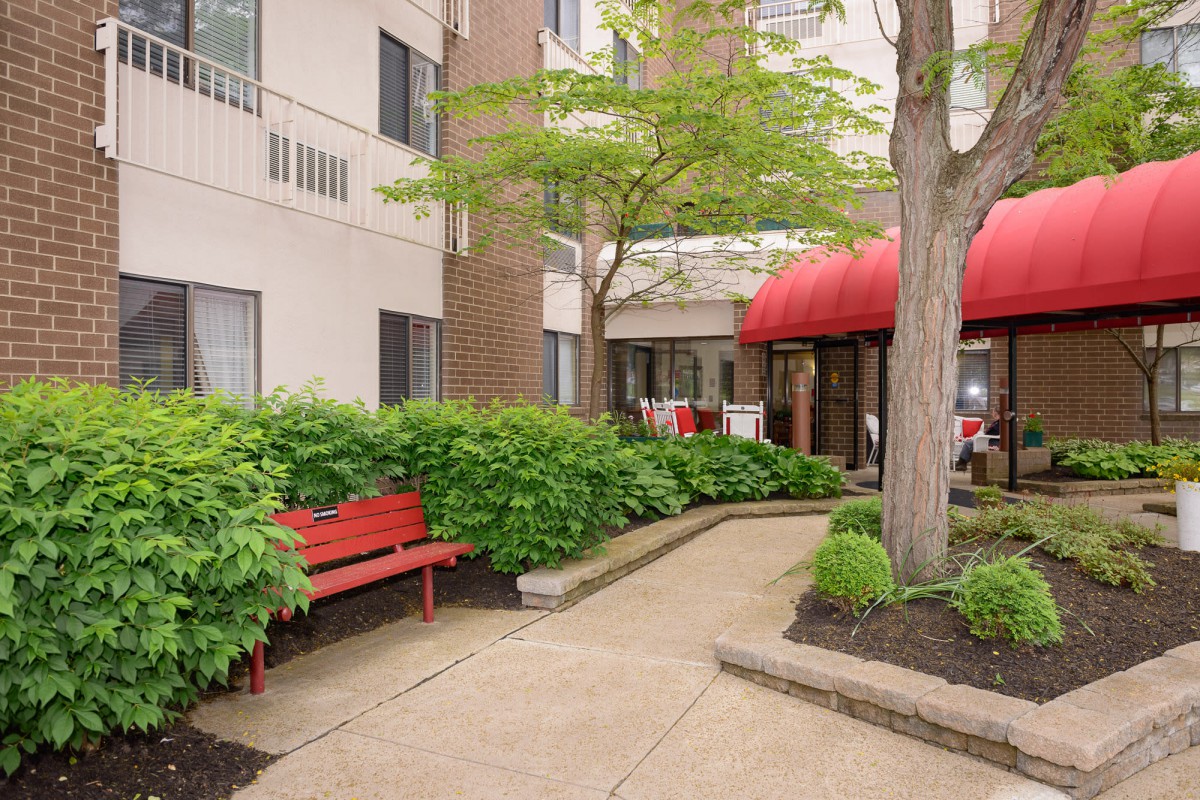 A peaceful courtyard with benches and lush greenery.
