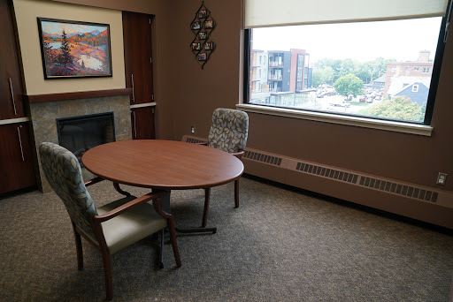A small meeting room featuring a round table and two chairs, with a window offering an outside view.