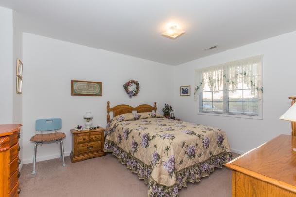A cozy bedroom with floral bedding and wooden furniture.