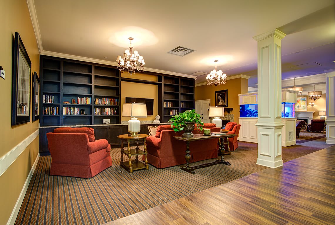 A cozy library interior with bookshelves, comfortable chairs, and warm lighting.