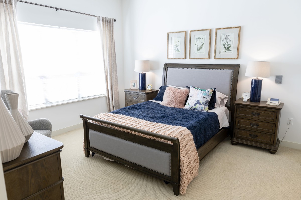 A modern bedroom with a sleek bed, nightstands, and decorative artwork on the walls.