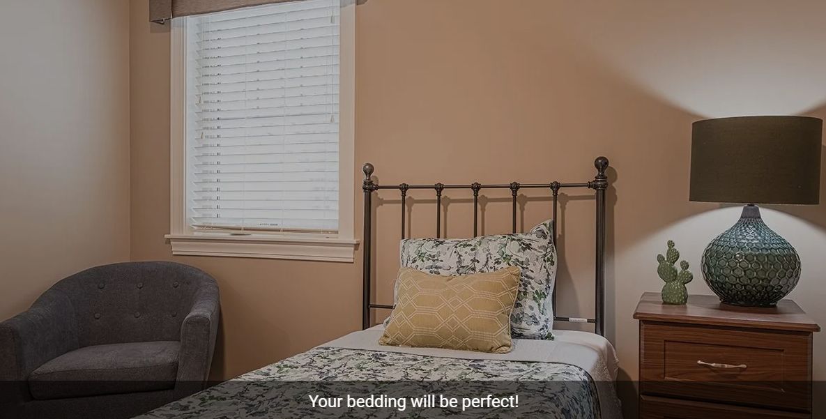 A neatly made bed with patterned pillows in a cozy bedroom setting.