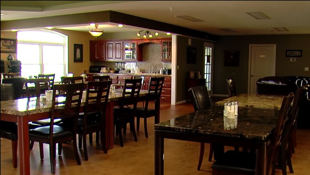 A spacious kitchen and dining area featuring wooden cabinets and a large dining table with bar stools.