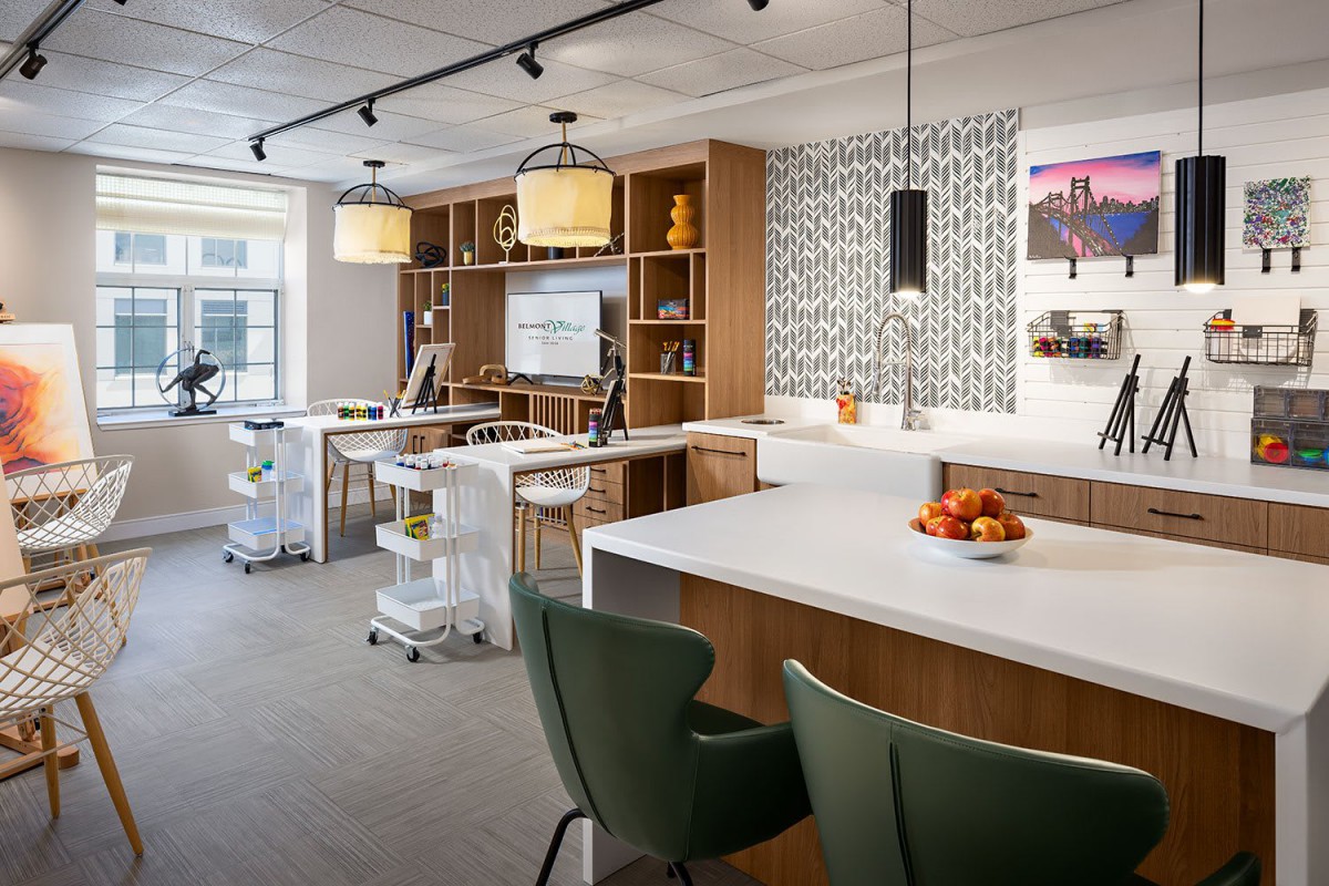 A modern kitchen interior with a central island, stylish seating, and decorative lighting.
