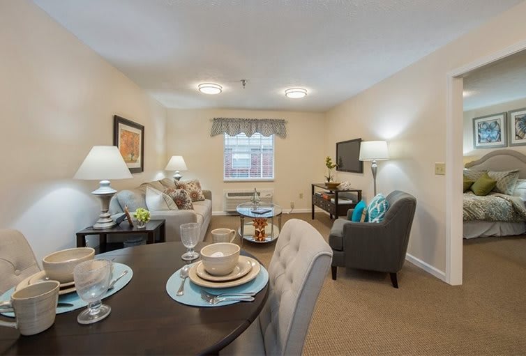 A cozy living room with a dining area featuring comfortable furniture and bright lighting.