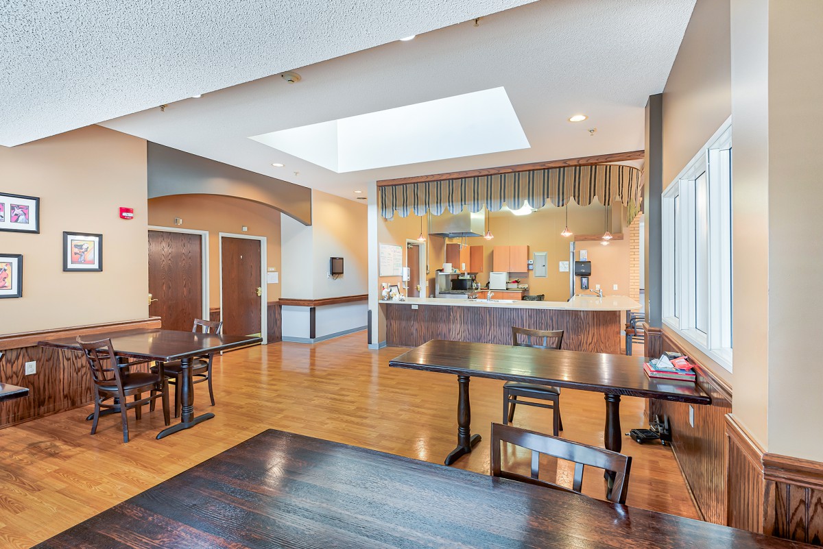 A modern open-concept kitchen and dining area with wooden flooring and contemporary furnishings.