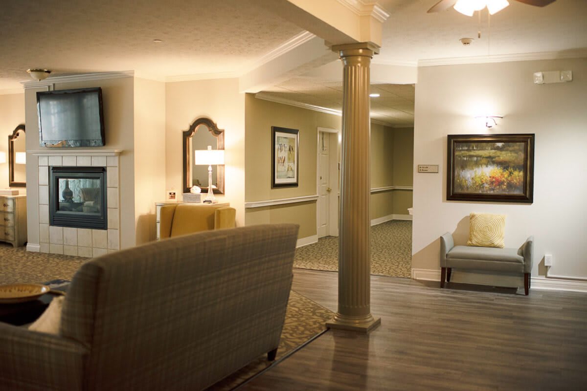 A cozy living room interior with a sofa, decorative column, and soft lighting.