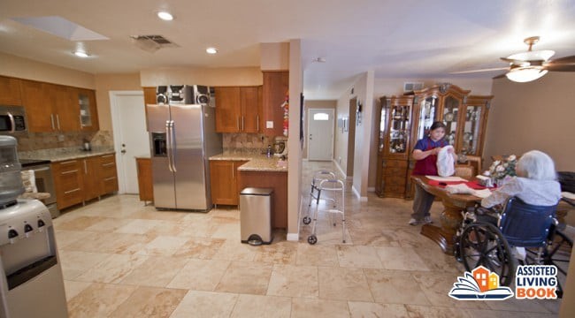 A modern kitchen interior with stainless steel appliances, wood cabinetry, and tile flooring.