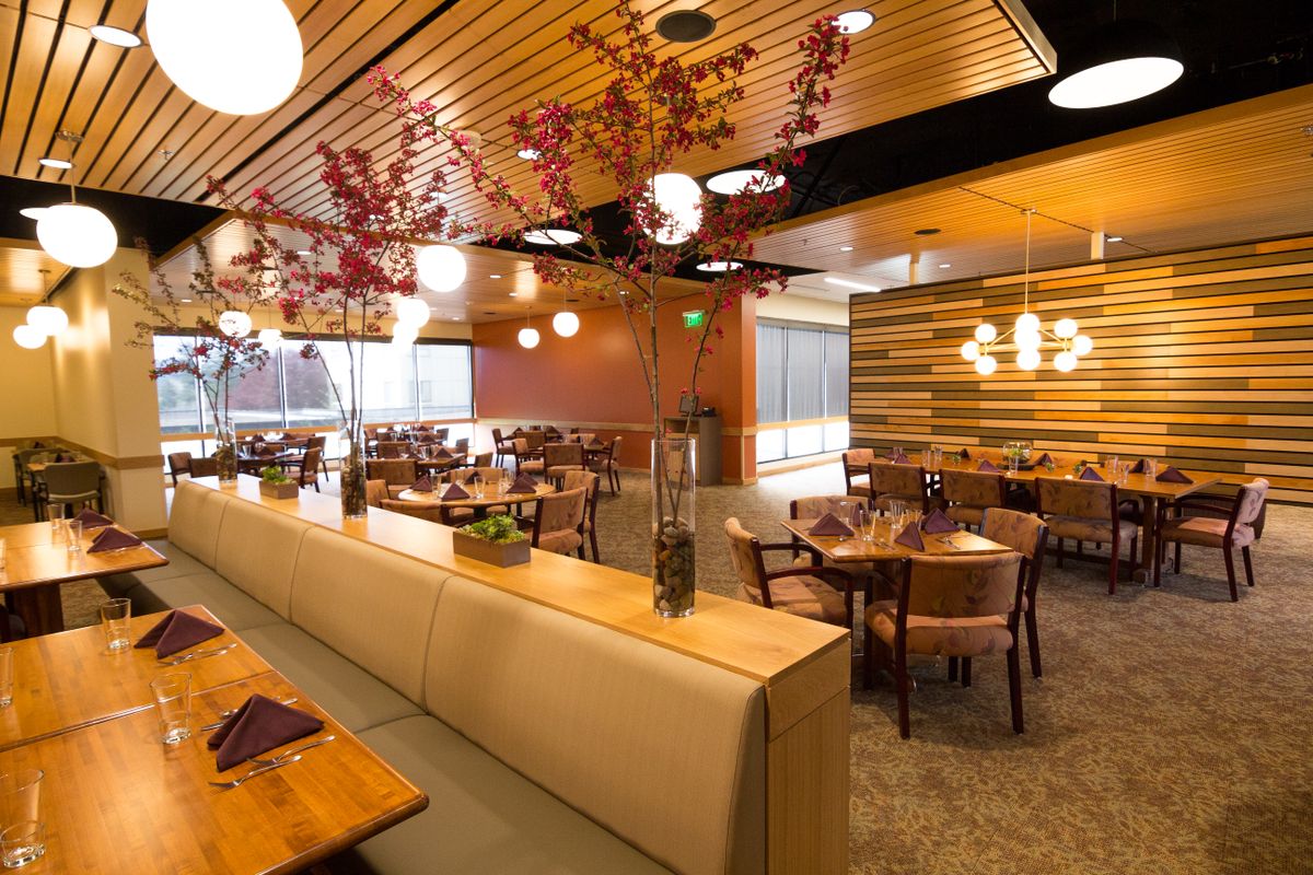 A modern restaurant interior with elegant wooden decor and warm lighting.