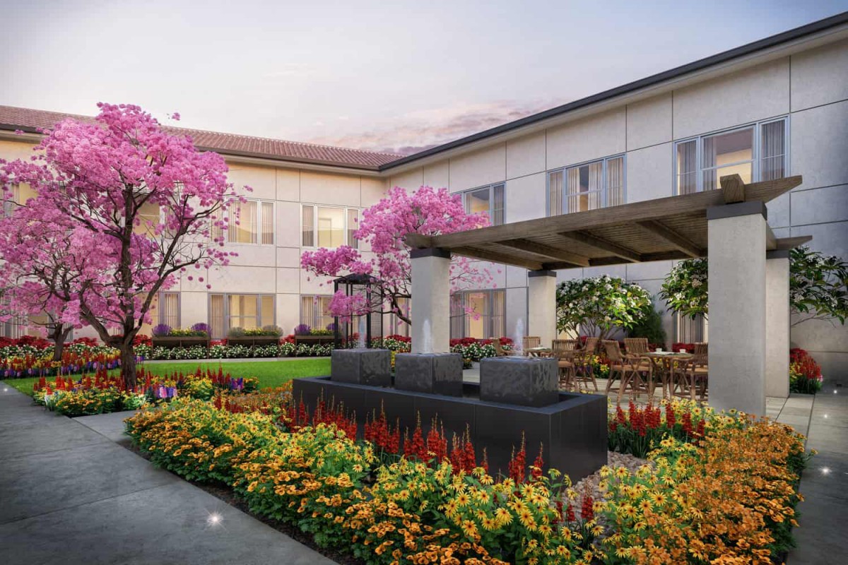 A beautifully landscaped courtyard with colorful flowers and elegant architecture.