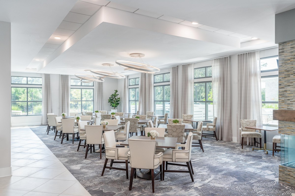 A modern dining room with elegant furniture and large windows.