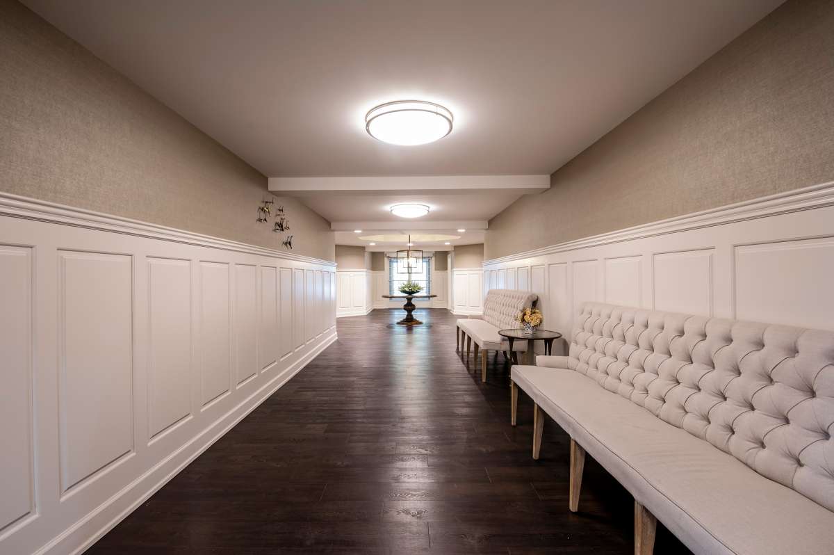 A modern hallway with elegant lighting and seating.