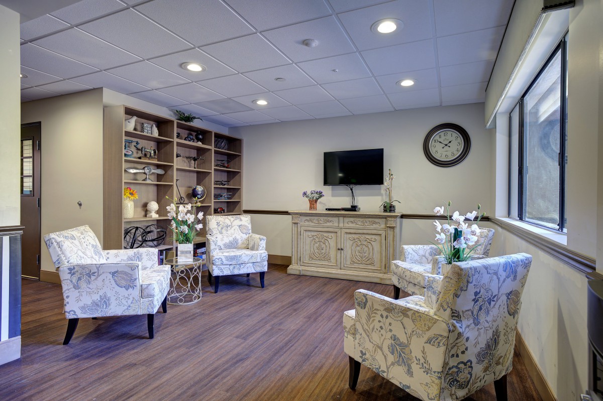 Cozy waiting room with comfortable seating and a wall-mounted television.