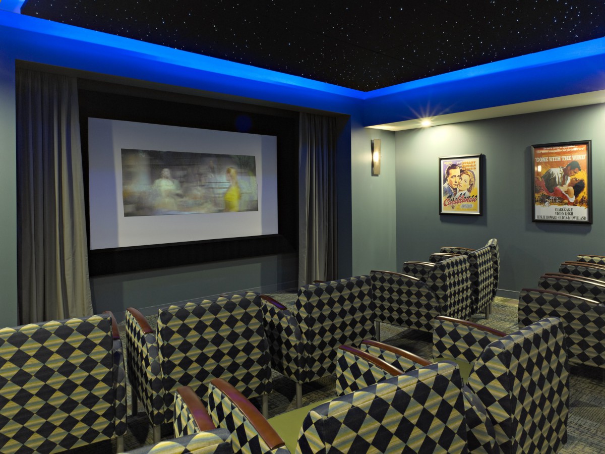A stylish home theater with patterned seating and ambient lighting.