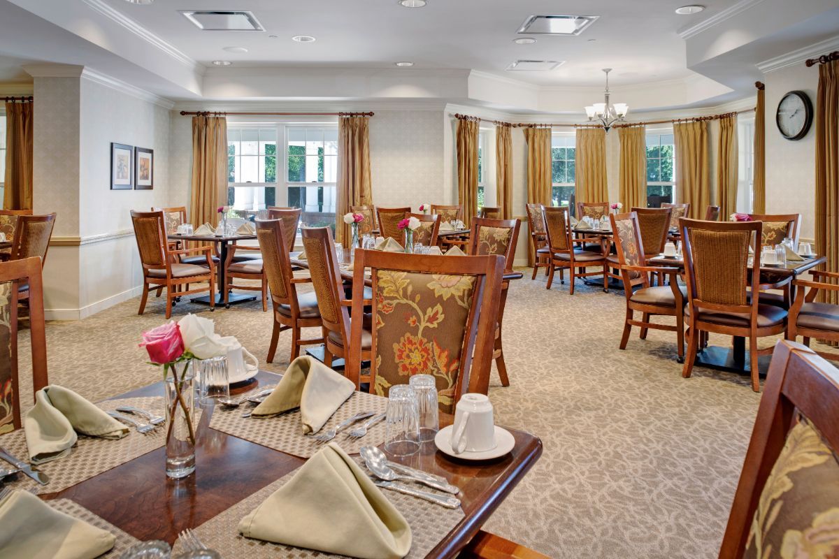 An elegant dining room with neatly arranged tables and chairs, set for a meal.