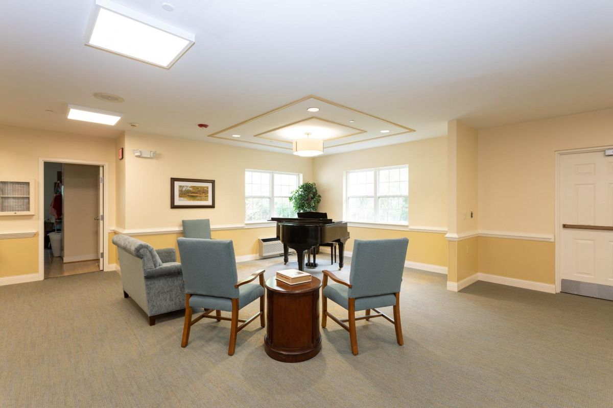 A cozy living room with a piano and seating area.