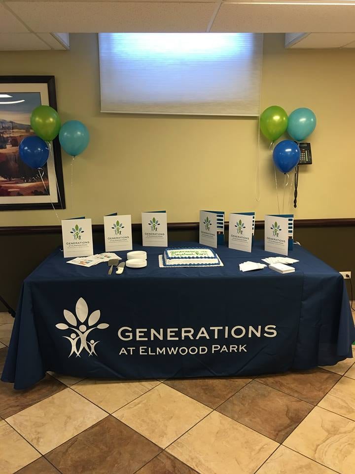A table display at an event for Generations at Elmwood Park, featuring brochures and balloons.