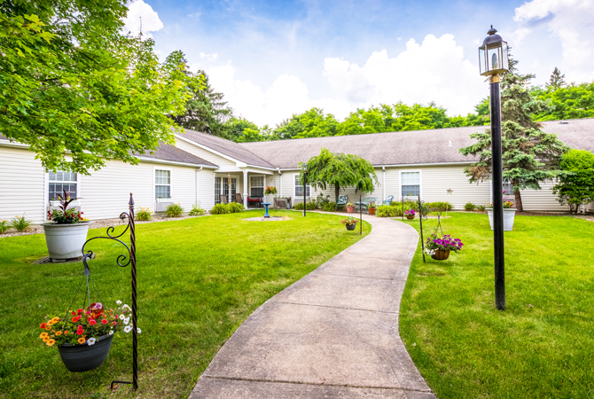 A scenic view of a house with a pathway leading through a well-maintained garden.