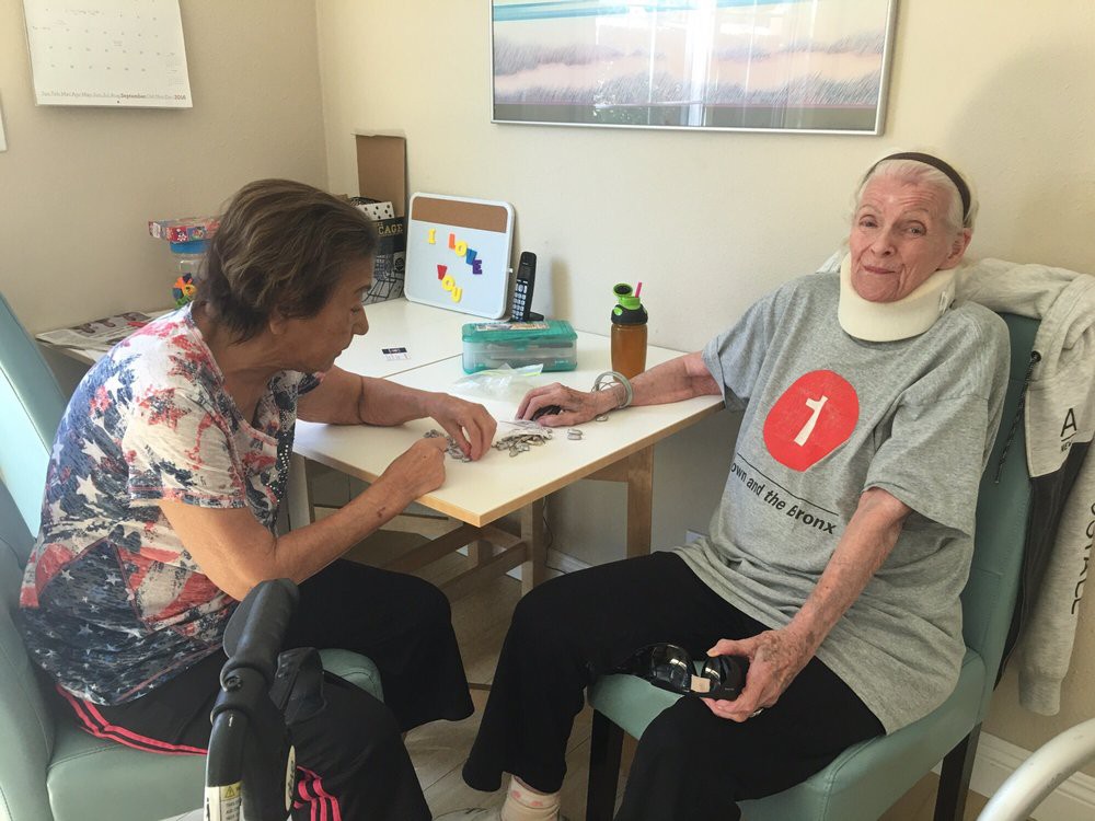 A nurse assists a patient during a rehabilitation session in a care facility.