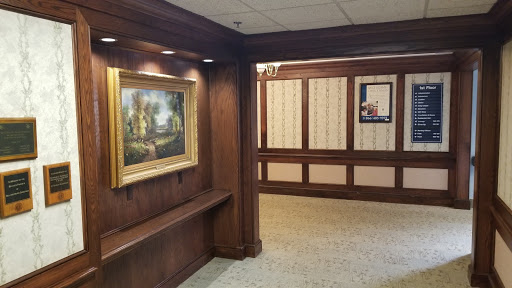 A well-lit hallway featuring an elegant painting and classic wood paneling.