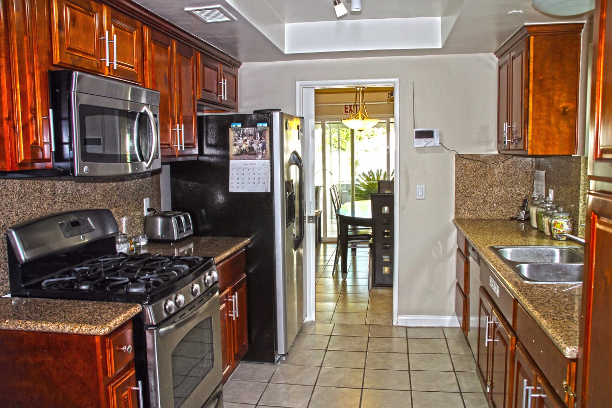 A modern kitchen with stainless steel appliances and wooden cabinets.