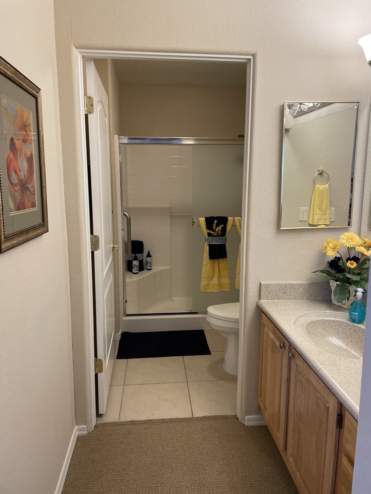A neatly organized bathroom with a shower, sink, and decorative elements.