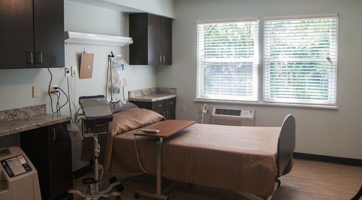 A hospital room with a patient bed and medical equipment.