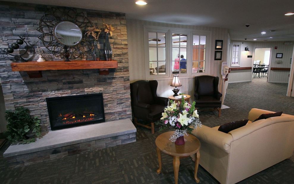 A cozy living room with a stone fireplace and comfortable seating.