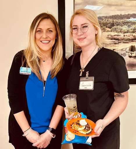 Two healthcare professionals enjoying a social event with snacks.