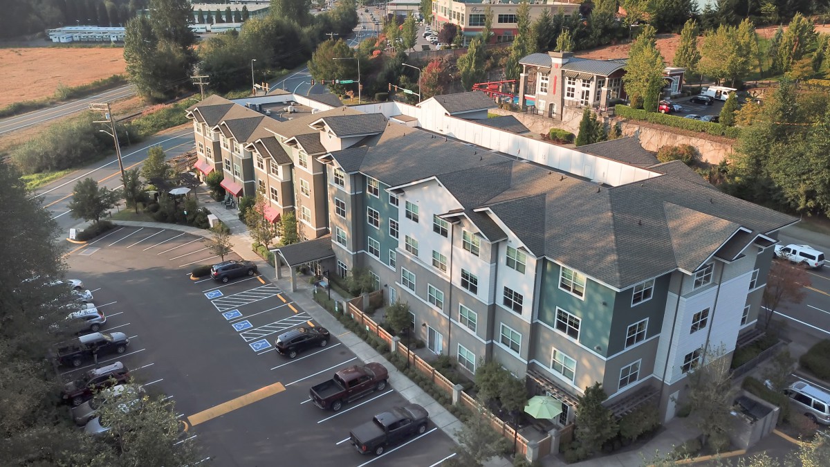 Aerial view of apartment buildings and a parking lot in a residential area.